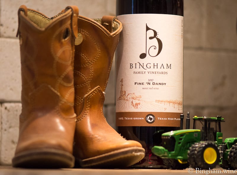 18.03.26_17FineNDandy_010-800web | Bingham Family Vineyards Bottle of Bingham Family Vineyards Fine 'n Dandy along with pair of small children's boots and toy tractor.