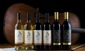 line of bingham family vineyards wine bottles in front of a cello
