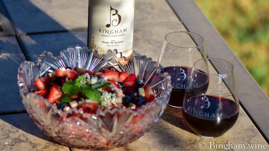 bowl of fruit salad and two glass of wine bingham family vineyards 2018 fine n dandy