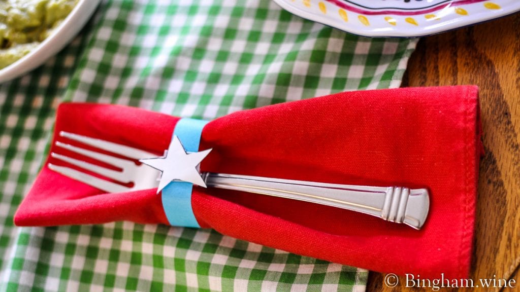 10.07.04_4thJulyDinner_008-1200-web-16x9-1 | Bingham Family Vineyards Fork on a red napkin with a paper napkin holder with a white start.