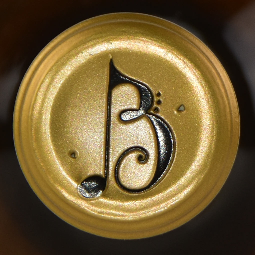 | Bingham Family Vineyards End cap of gold capsule on the top of a bottle of Bingham Family Vineyards wine with their logo