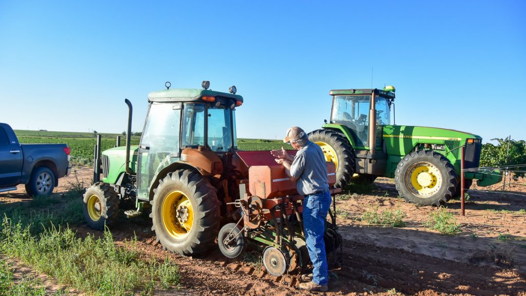230924_covercropseedsplanter_002-1200-web-16x9 | Bingham Family Vineyards Cliff Bingham filling planter box with seed for cover crop between rows of vineyard at Bingham Family Vineyards
