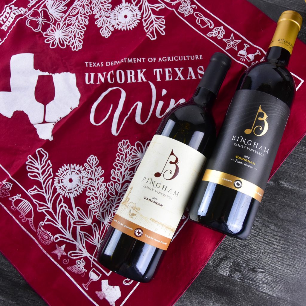 231026_19carignan20reservecarignan_0011200web1x1 | Bingham Family Vineyards bottles of 2019 Bingham Family Vineyards Carignan and 2020 Reserve Carignan lying on Texas Department of Agriculture Uncork Texas wine red kerchief