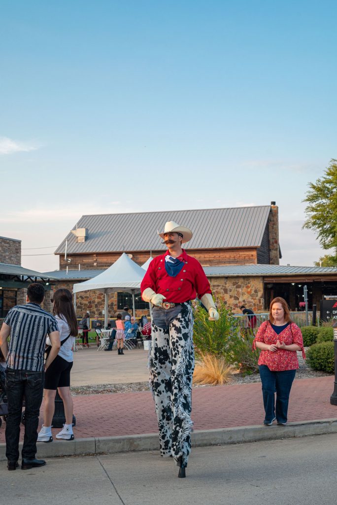 man in western attire on stilts at Celebrate Roanoke, Texas