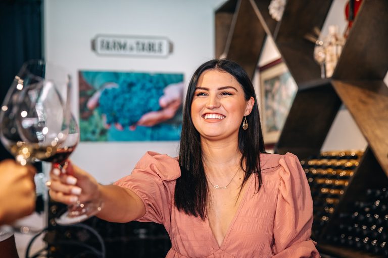 Visit Grapevine | Bingham Family Vineyards A woman enjoying a glass of wine at Bingham Family Vineyards with friends