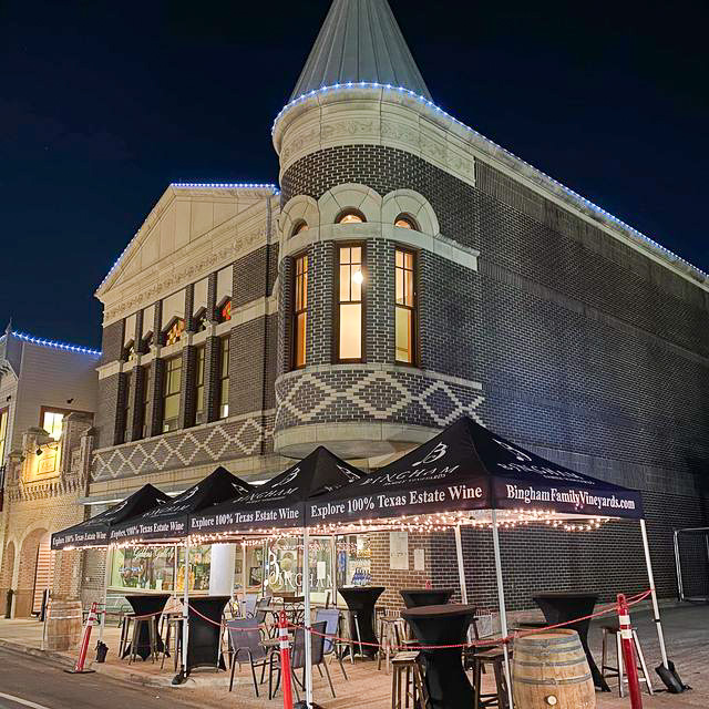 Exterior of Bingham Family Vineyards with tents in front at Grapefest, Grapevine, Texas with lights at night.