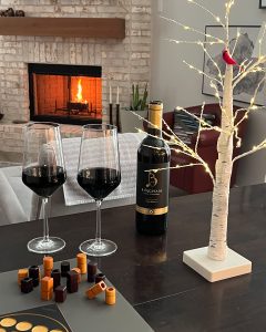 Bingham Reserve Wine with two glasses in front of a wood fireplace