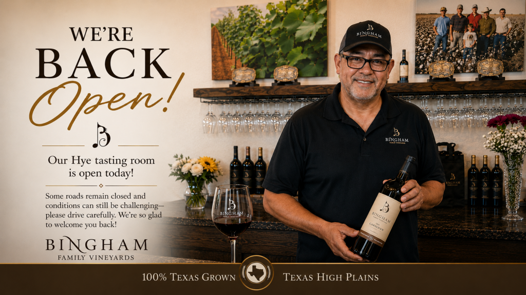 J.R. holding bottle of Bingham Wine at Bingham Family Vineyards Hye Tasting Room welcoming people back after being closed because of heavy rains.