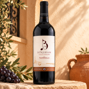 2021 Tempranillo: Bingham Family Vineyards 2021 Tempranillo bottle in a warm Spanish-inspired stucco setting with grapes, olive leaves, and a clay pot.